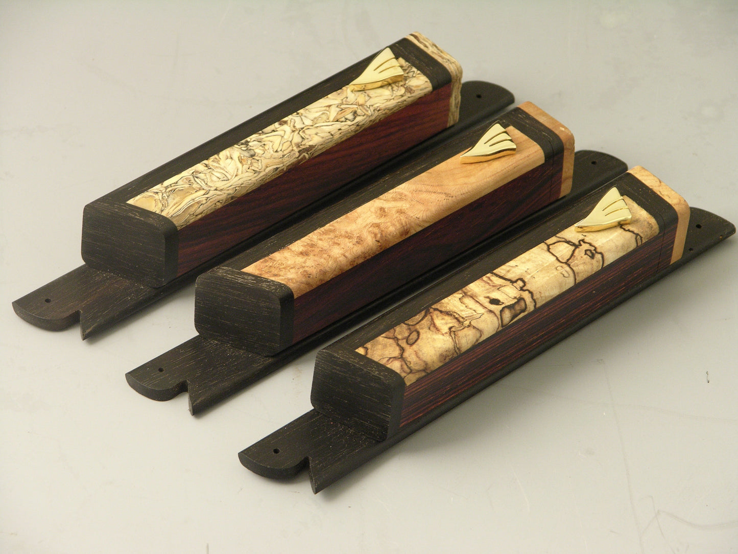Mezuzah Cases (EC5) featuring handcrafted cocobolo wood bodies with gold plated shin symbols and ebony mounting bases, ideal for religious use.