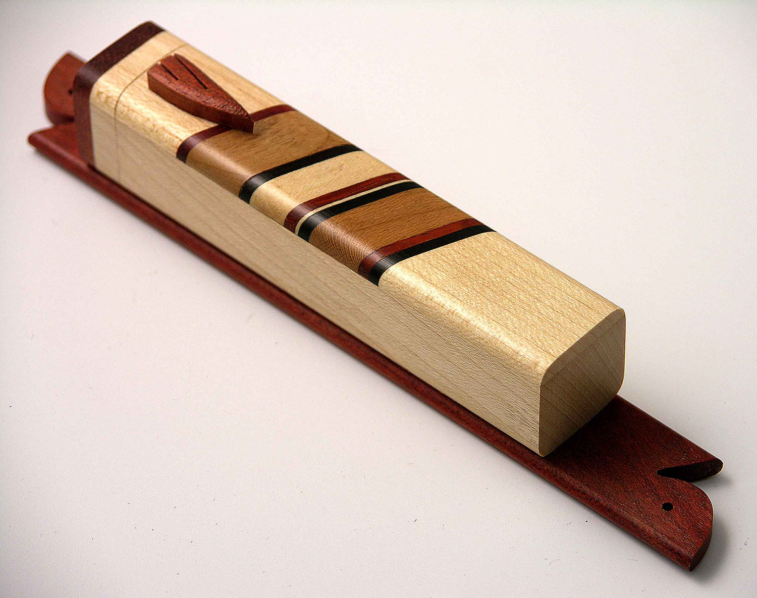 EC1A mezuzah case in mixed hardwoods (bloodwood, cherry, cocobolo, ebony) with carved wooden shin and removable lid.