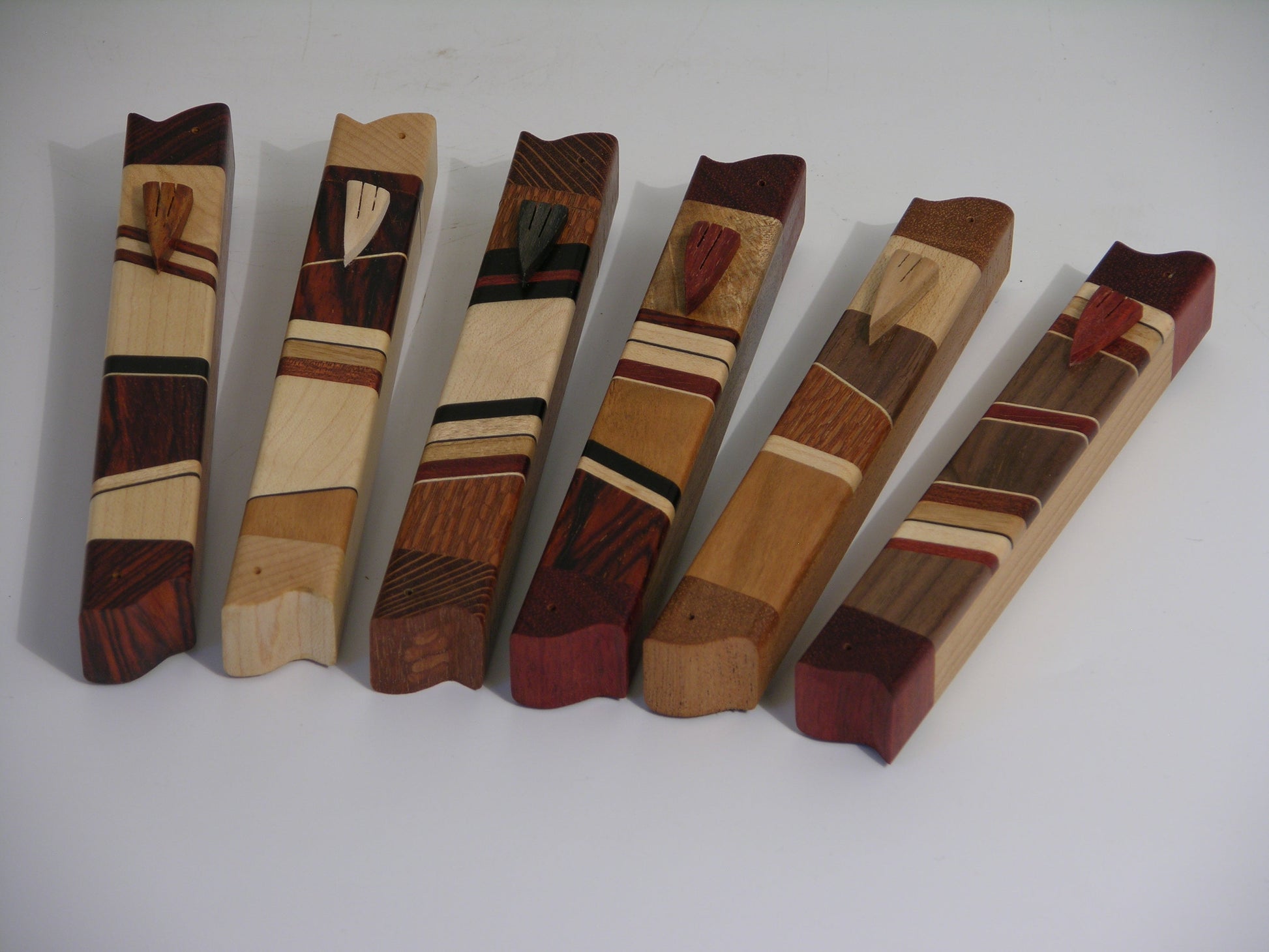 EC3A mezuzah case in mixed hardwoods with carved wooden shin; approx. 4.75 inches long.