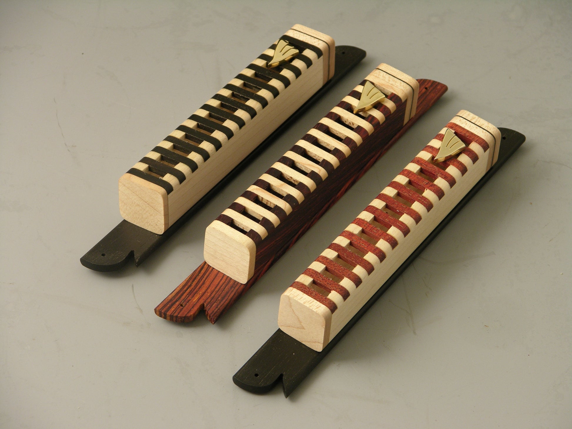 Mezuzah Cases (EC8) with handcrafted open grid design in natural wood tones, showcasing scroll visibility and mounted on decorative plates.